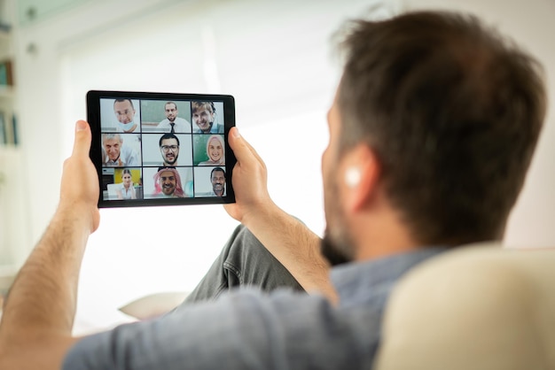 Mid adult man having online conference working from home