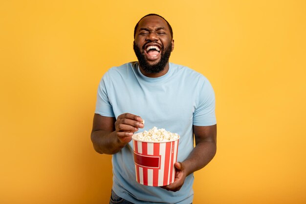 Mid adult man holding ice cream against orange background