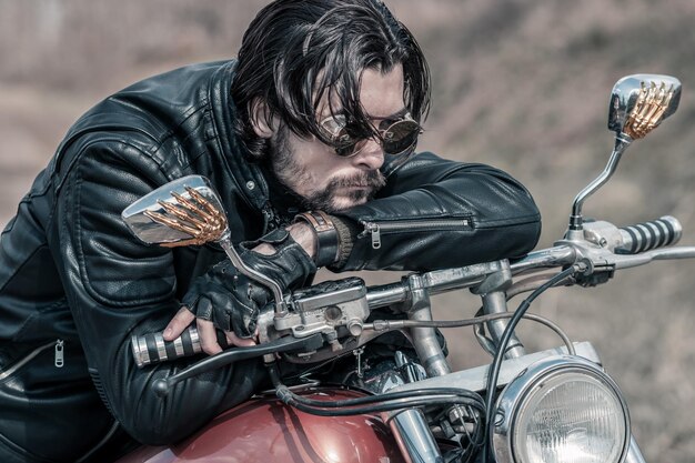 Photo mid adult man leaning on motorcycle in forest