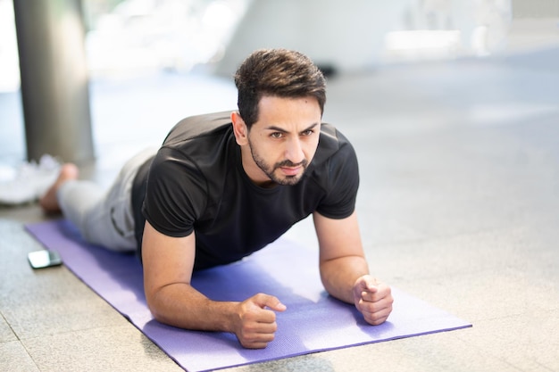 Foto uomo adulto medio in posizione di tavola sul tappetino da ginnastica