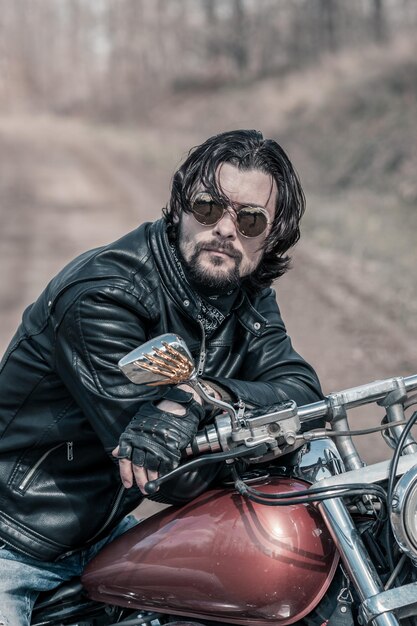 Photo mid adult man sitting on motorcycle in forest