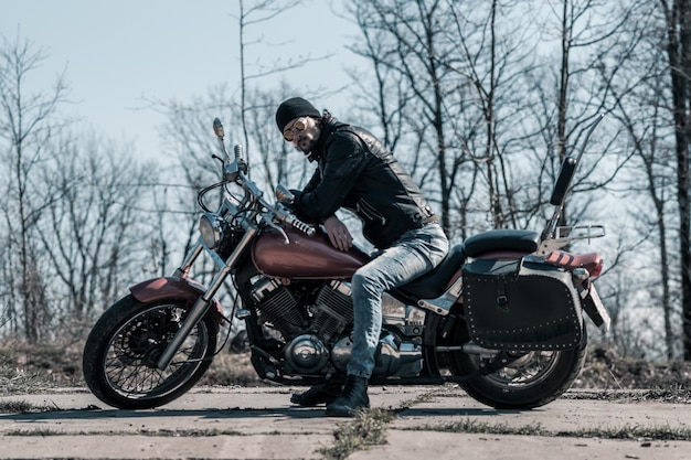 Photo mid adult man sitting on motorcycle in forest