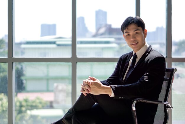 Photo mid adult man sitting in window