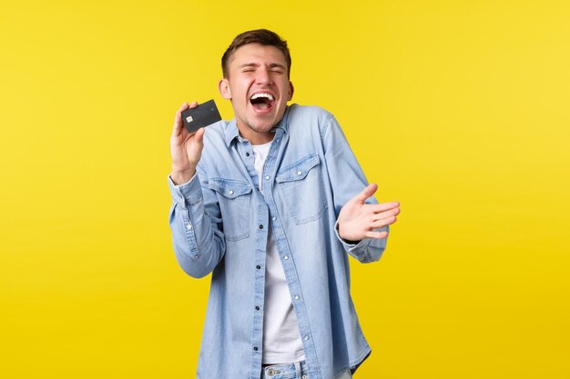 Mid adult man standing against yellow background