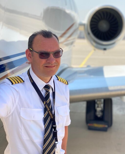 Mid adult man standing by airplane at airport