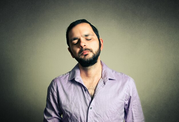 Photo mid adult man standing with eyes closed against gray background