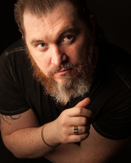 Photo mid adult man with beard against black background