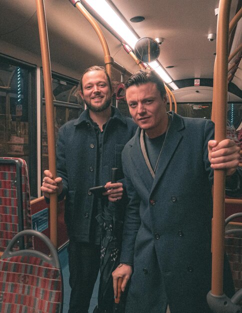 Foto uomini adulti in piedi sul treno.