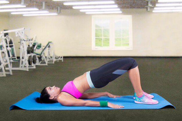 Photo mid adult woman doing yoga in gym