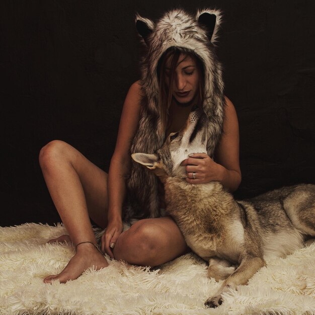 Photo mid adult woman embracing fox while sitting on rug