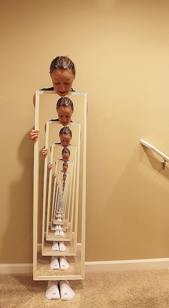 사진 집 의 바닥 에 반사 된 거울 을 들고 있는 중년 여성