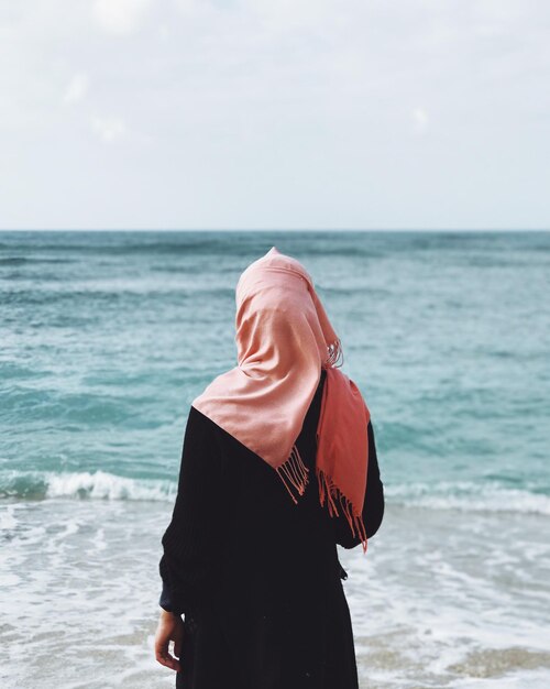 写真 空に照らしてビーチに立っている中年女性