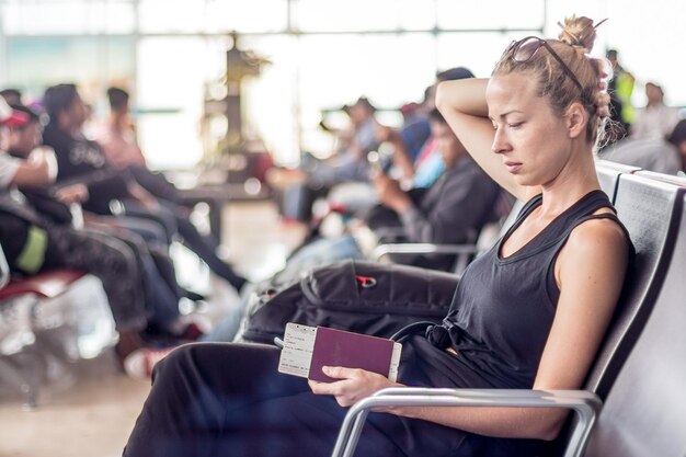 Photo mid adult woman sitting on airport