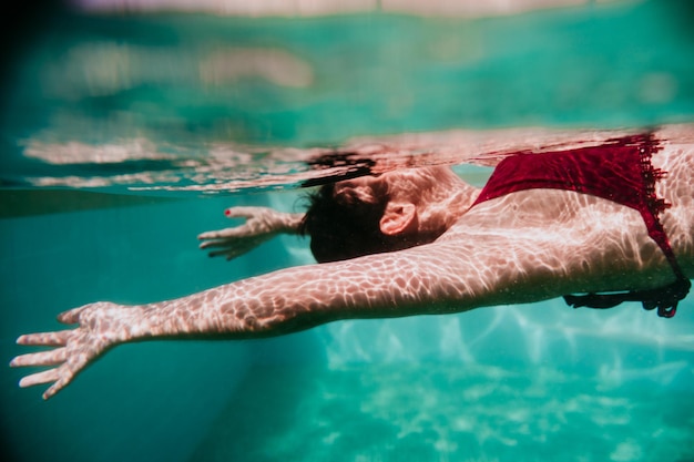 写真 プールで泳いでいる中年女性