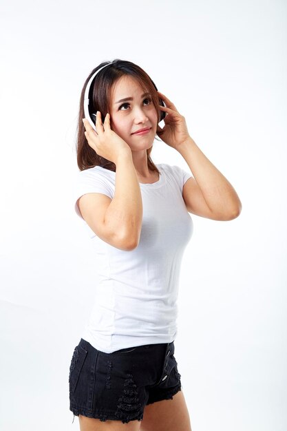 白い背景に立っているヘッドホンを持った中年女性