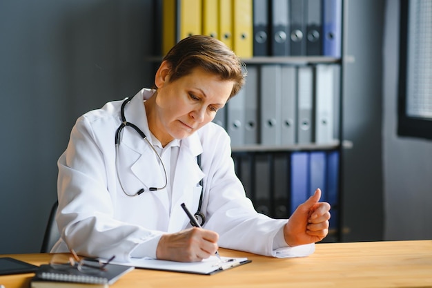 Mid age female doctor writing prescription