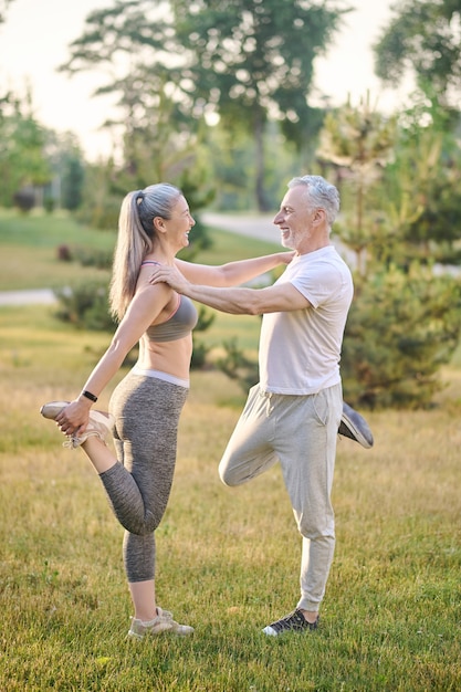 A mid aged couple stretching before the morning workout