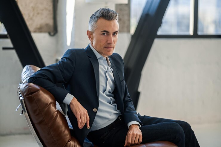 Mid aged goodlooking man sitting in the office and looking confident