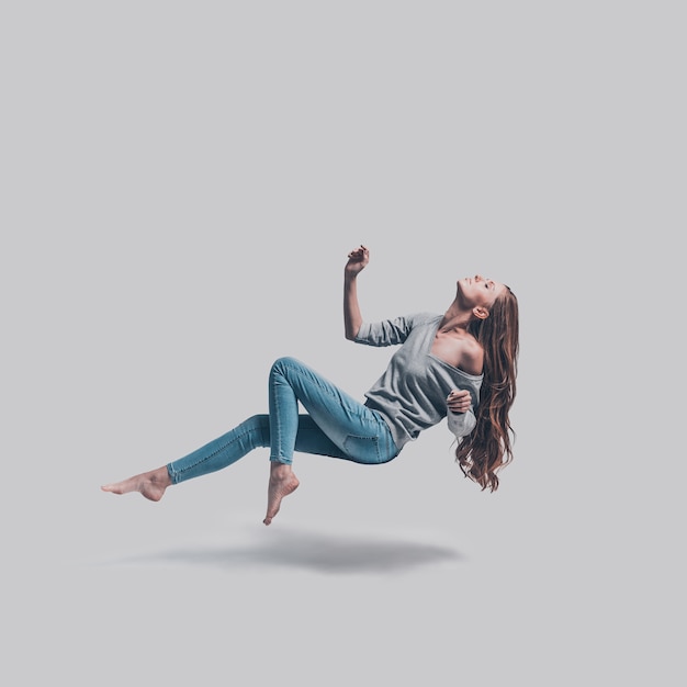 Photo mid-air beauty. full length studio shot of attractive young woman hovering in air and keeping eyes closed