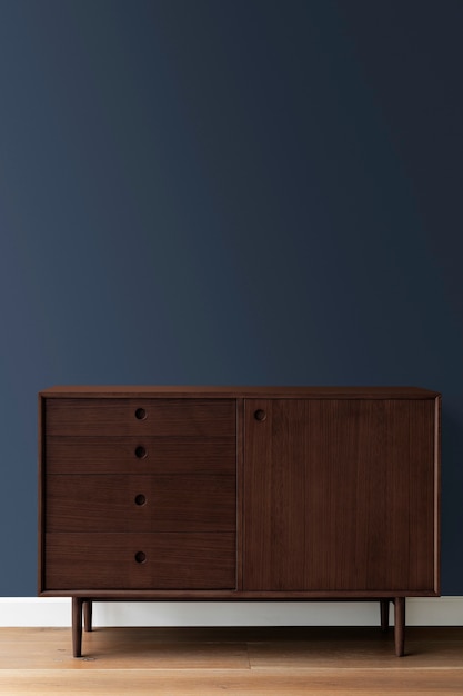 Photo mid century modern wood cabinet by a blue wall