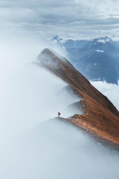 Vista a mezza distanza di un uomo in piedi sulla cresta della montagna