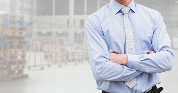 Mid section of businessman standing with arms crossed