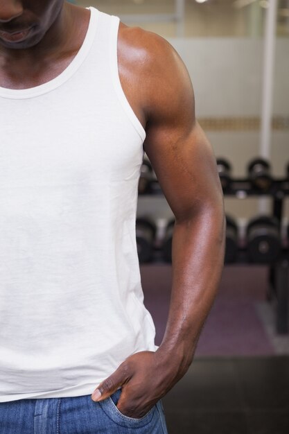 Mid section of a cropped muscular man in gym