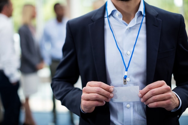 Mid section of employee showing Id card