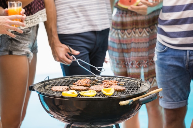 Metà di sezione di amici che preparano il barbecue