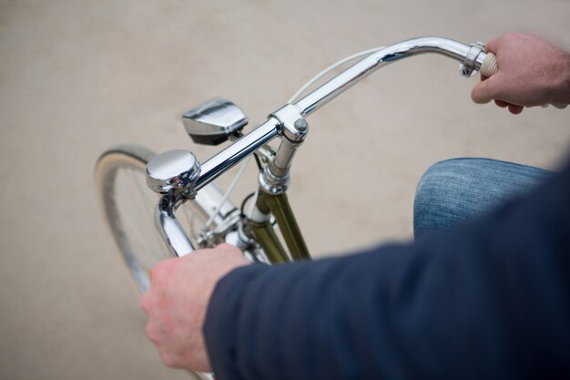 Mid section of man riding bicycle on beach