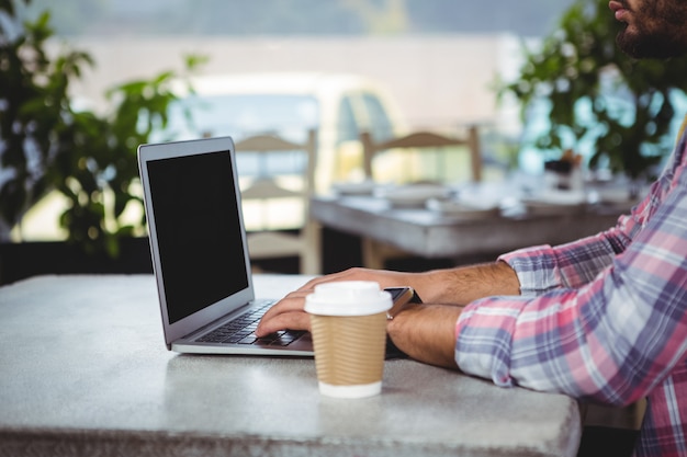 Foto mezzo sezione dell'uomo che per mezzo del computer portatile