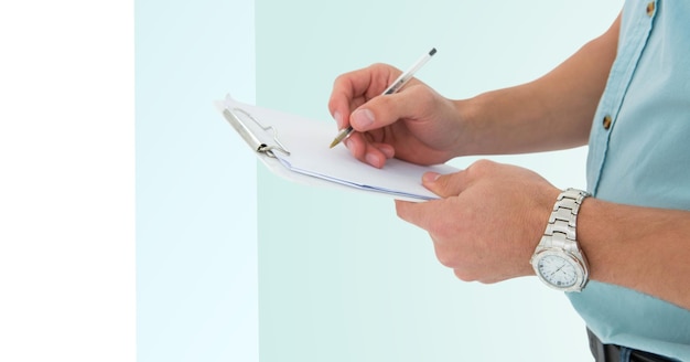 Mid section of man writing on a clipboard