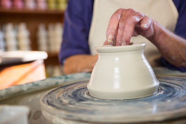 Mid section of potter making pot