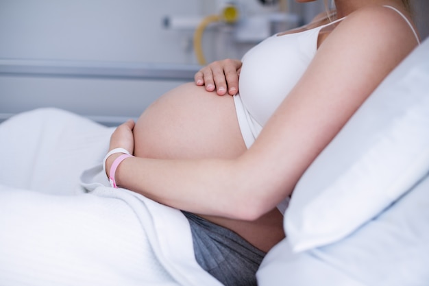 Средняя часть беременной женщины расслабляющий на больничной койке