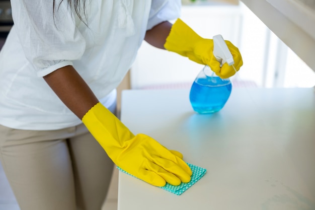 Mid-section van vrouw die de keuken schoonmaakt