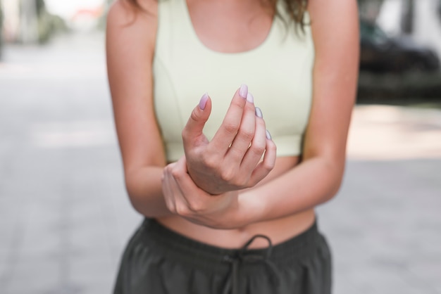 Metà di sezione della donna che ha dolore in mano