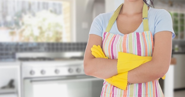 Mid section of woman standing with arms crossed standing in kitchen