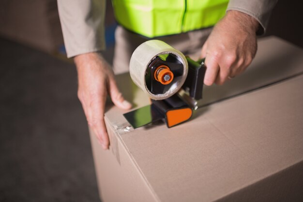 Photo mid section of worker preparing goods for dispatch