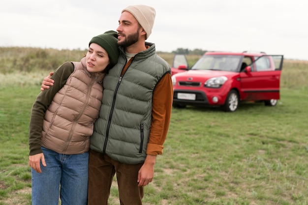 Photo mid shot couple embracing in front of car