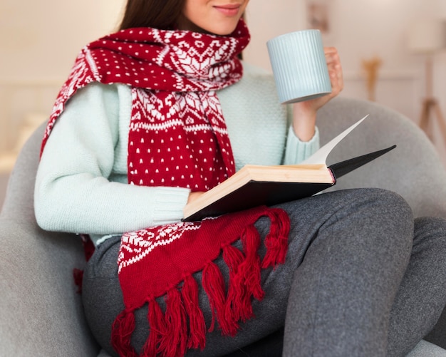 Mid shot cozy woman with scarf and book