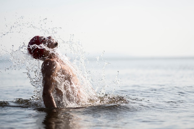 Mid shot man splashing out of water