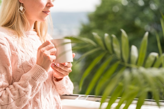 Metà tazza donna che tiene tazza