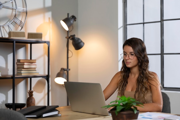 Mid shot woman looking at laptop