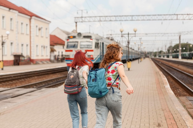 Женщины в середине кадра бегут после поезда