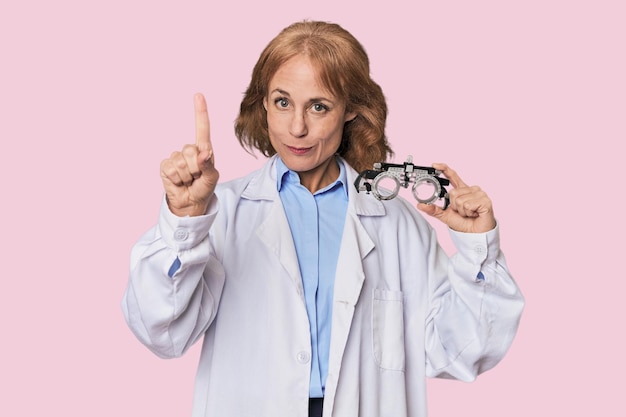 Midaged Caucasian optometrist in studio showing number one with finger