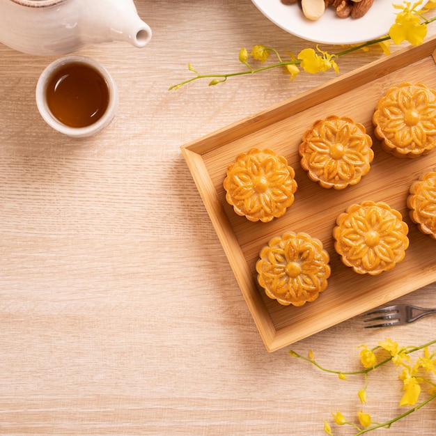 MidAutumn Festival holiday concept design of moon cake mooncakes tea set on bright wooden table with copy space top view flat lay overhead shot