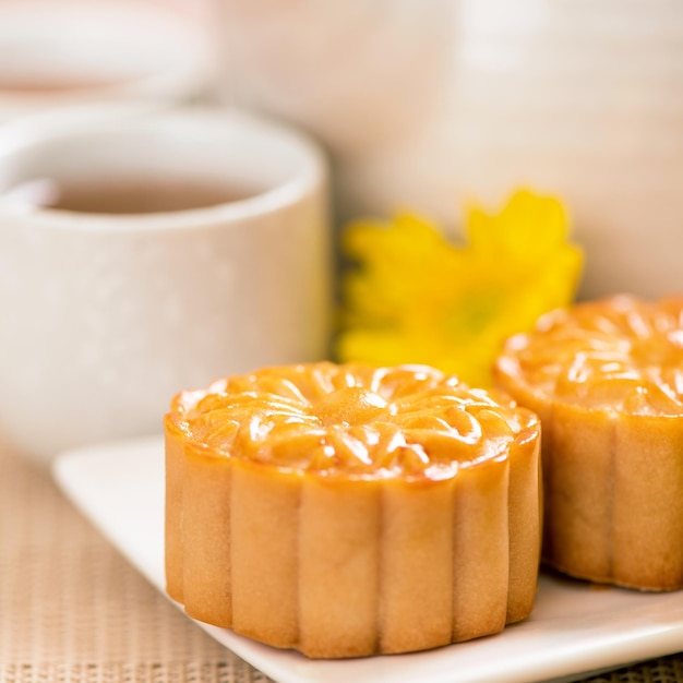 MidAutumn Festival holiday concept design of moon cakemooncakestea set on bright wooden table and serving plate with copy space close up