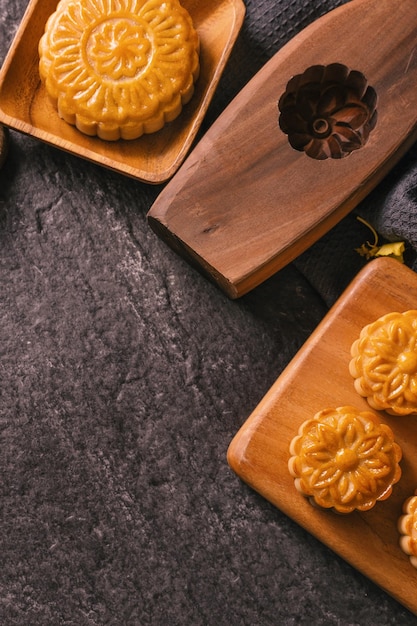 MidAutumn Festival traditional food concept Beautiful Moon cake on black slate table with tea pastry mold flower top view flat lay copy space