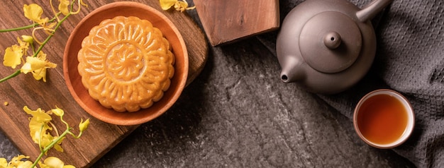 MidAutumn Festival traditional food concept Beautiful Moon cake on black slate table with tea pastry mold flower top view flat lay copy space