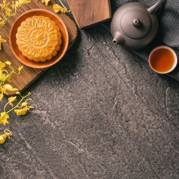 MidAutumn Festival traditioneel eten concept mooie maan cake op zwarte leisteen tafel met thee gebak schimmel bloem bovenaanzicht plat lag kopie ruimte